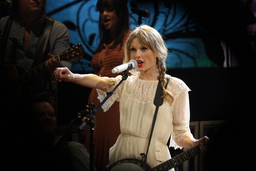 Taylor Swift står på scenen och sjunger.