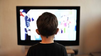 Ett barn sitter framför tv:n.