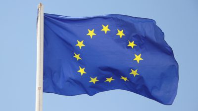 En EU-flagga är fäst på en flaggstång och vajar i vinden.