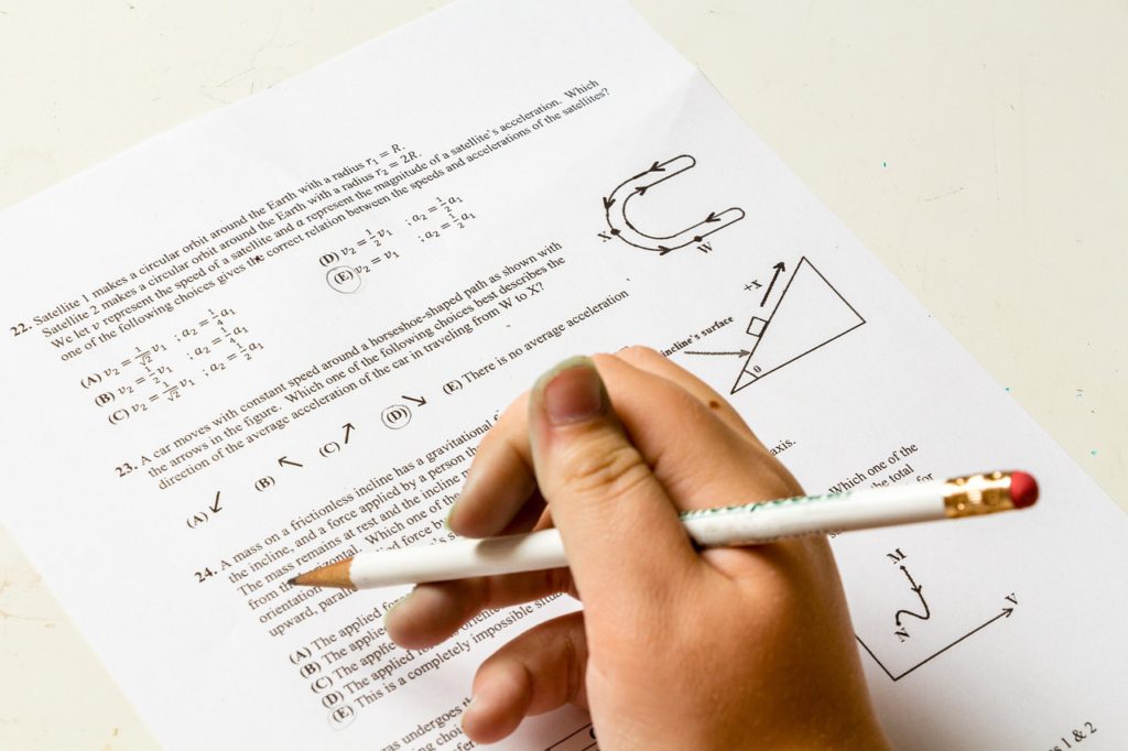 En hand håller en penna ovanför ett mattetest